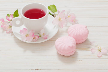 Red tea with flowers on white wooden background