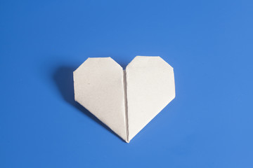 Paper origami Valentines Day heart on blue background