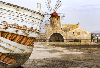 Dettagli di una barca nella salina di Trapani con mulino sullo sfondo