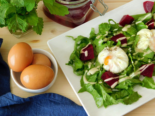 Poached eggs on a salad with pieces of beetroot. View from above. Restaurant dish