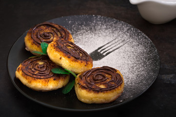 Cheese pancake with chocolate. Old black background. Close-up. Top view