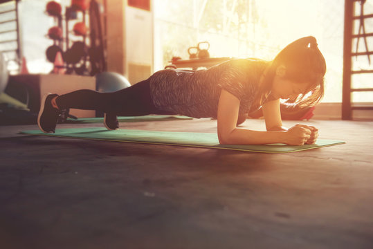 Healthy Women Doing Planking Exercise in gym