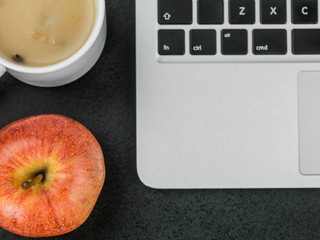 Cup of Mushroom Soup With a Red Apple and a Laptop Computer