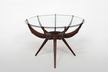 Circular glass topped designer table with tripod bass legs.