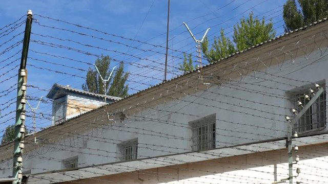 The prison is surrounded by a fence with barbed wire under high voltage