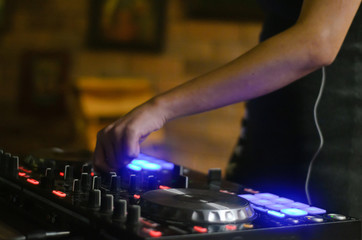 Hands disc jockey at the turntable. DJ plays on the best, famous CD players at nightclub during party. EDM, party concept.