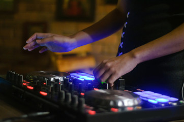 Hands disc jockey at the turntable. DJ plays on the best, famous CD players at nightclub during party. EDM, party concept.