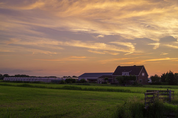 a dutch farmhouse on the country side at sunset / dusk in the Netherlands.