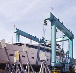 Crane lifting boats at harbor