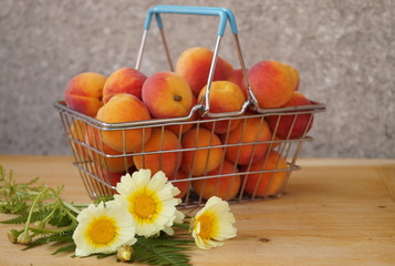 Basket of apricots and yellow flowers
