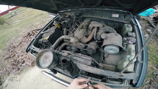 POV Man fumbling with the old machine in the engine compartment.
