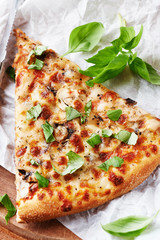 Rustic pizza topped with fresh basil leaves