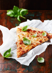 Rustic pizza topped with fresh basil leaves