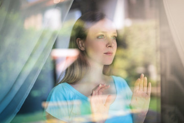 Portrait of a beautiful girl looking out from a window