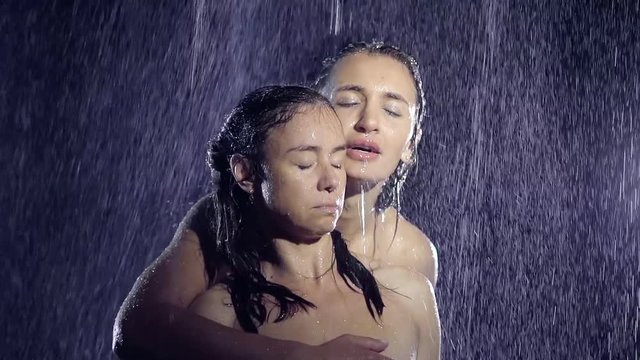 cute girls lesbian bathe together under a shower. one took the other from the back and caressing rubs her shoulder, hand covering his bare chest. homosexual relationships