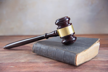 Obraz premium Judge gavel on an old book on a rustic wooden table, concept for justice in law and court, vintage color, copy space