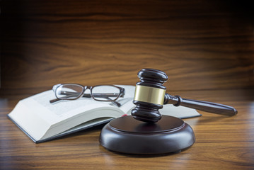 Judge gavel with sound board, book and glasses on a wooden desk, lawyers working place with justice...