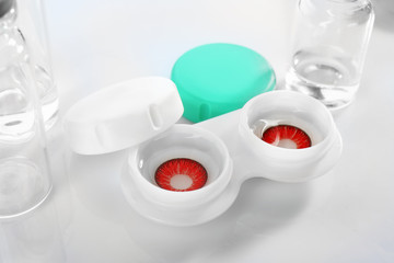 Container with contact lenses on white background