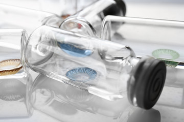 Bottles with contact lenses on white background