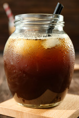 Jar with cold brew coffee on wooden table