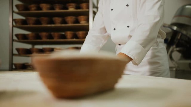 Close up shot of man hands making breads from the dough in the modern bakery backgroun with breads reck.