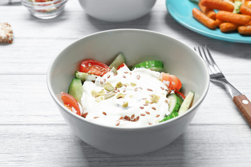 Fresh salad with yogurt on table