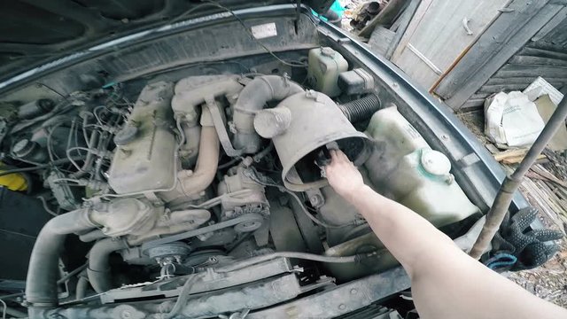 POV Man fumbling with the old machine in the engine compartment.