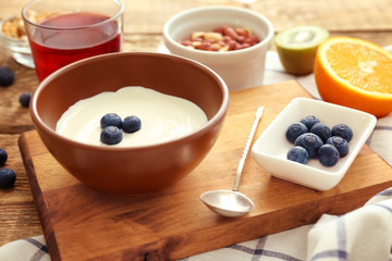 Tasty breakfast with yogurt on table