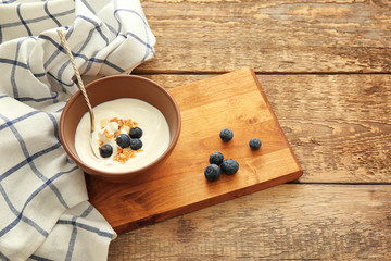 Bowl with tasty yogurt on table