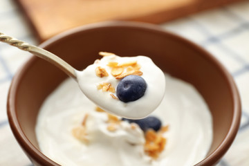 Spoon with tasty yogurt, closeup