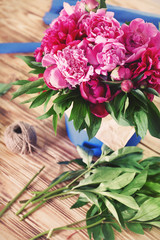 Beautiful peonies on wooden table in flower shop