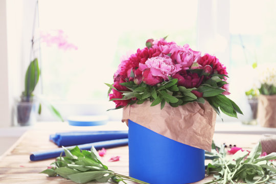 Gift carton with peonies on table in flower shop