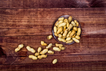 peanuts in shells with fresh groundnut on wooden on nature background