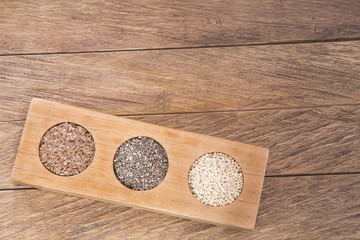 Flaxseed, chia and quinoa on wooden table