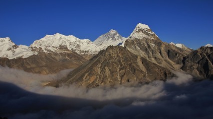 Fototapeta premium Above the clouds. High mountains Lobuche, mount Everest and Cholatse seen from the Gokyo valley.