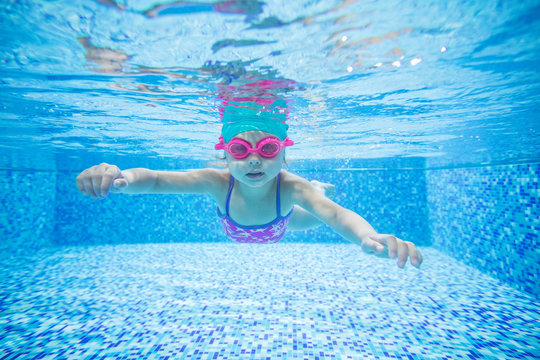 Little girl diving in swimming pool
