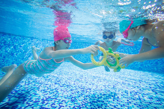 Kids swimming underwater and playing with toys