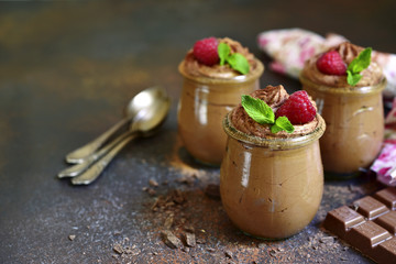 Chocolate mousse with fresh raspberry and mint in a vintage glass jar.