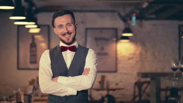 Smiling young waiter in cafe