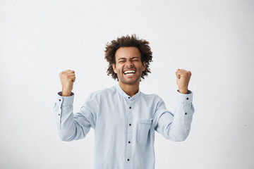 People, success, triumph, victory, winning and celebration. Happy successful young black...