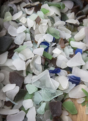 a birds eye view photograph of a collection of blue, white, green and brown sea glass