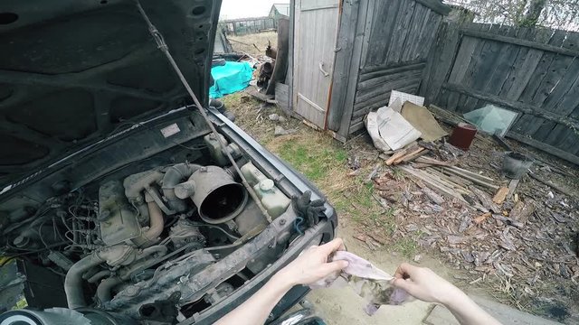 POV Man fumbling with the old machine in the engine compartment.