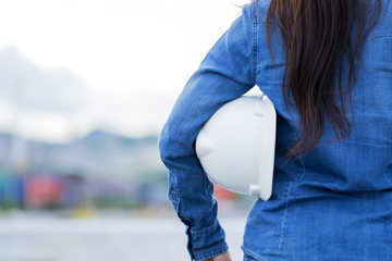 Professional Woman Engineer Holding White Helmet, Standing at Construction site for measure the...