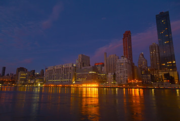 Fototapeta na wymiar Manhattan panorama at dusk as seen from Roosevelt Island in New York, USA. New York night scene with East River waterfront illuminated buildings.