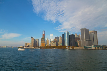 Fototapeta premium Panorama Dolnego Manhattanu z wody jesienią, Nowy Jork, USA. Zabytki architektury dzielnicy finansowej przed zachodem słońca.