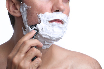 Young man shaving beard