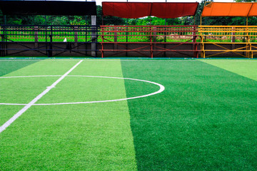 Photo of a green synthetic grass sports field with white line shot from above