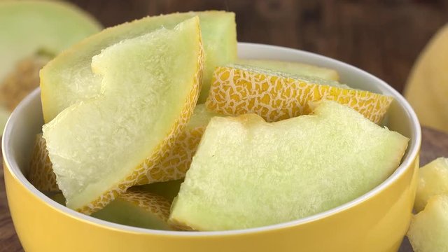 Honeydew Melon (chopped) rotating on a wooden plate (not loopable; 4K)