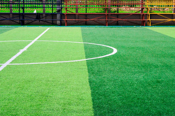 Photo of a green synthetic grass sports field with white line shot from above