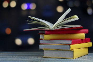 book on wood table and soft blur bokeh background, concept as opening paper will see knowledge of the world, learning by yourself and improve your life everywhere
